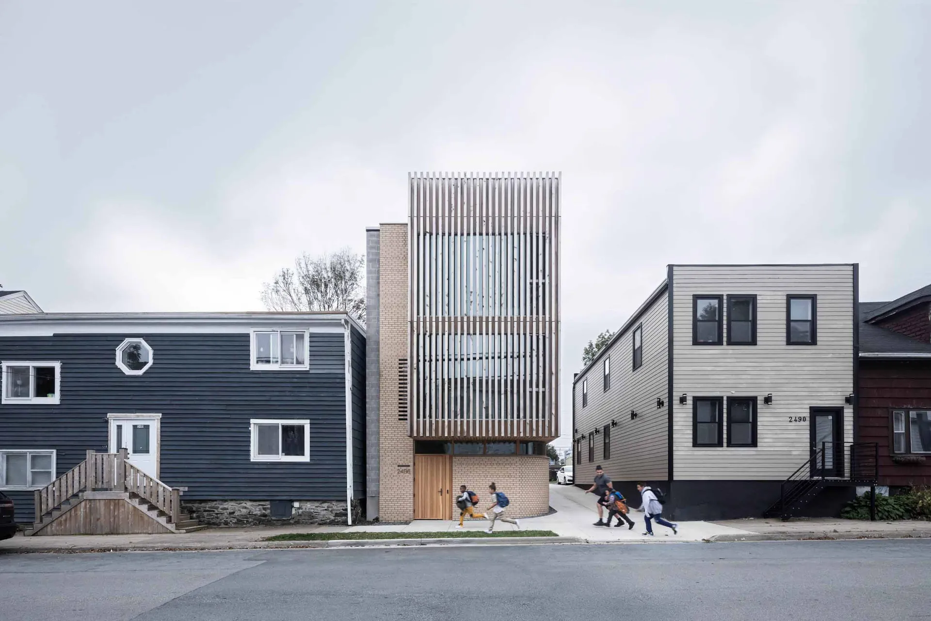 A modern residential building with brick, wood, and metal elements.