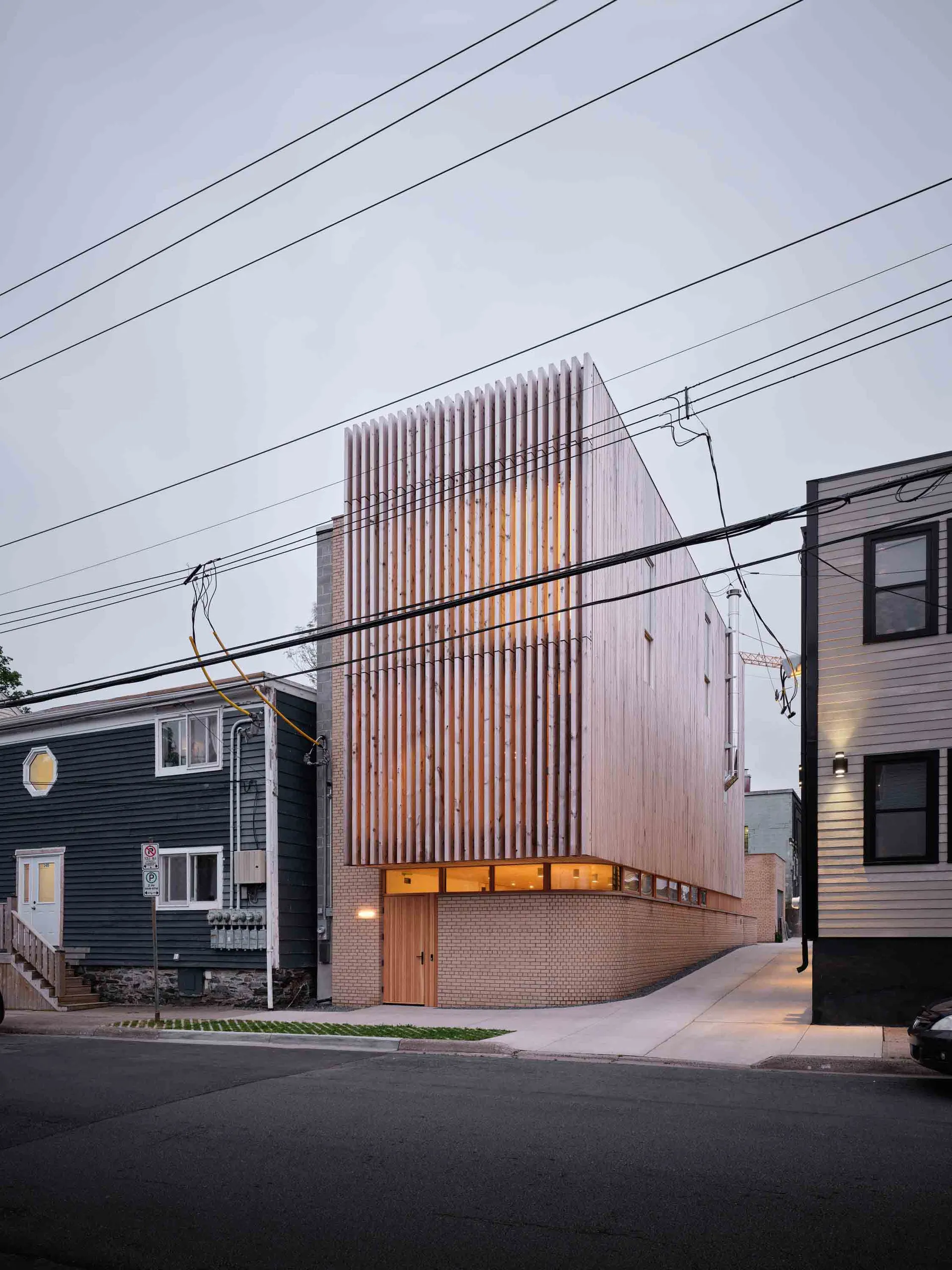 A modern residential building exterior featuring a combination of wood and brick materials.