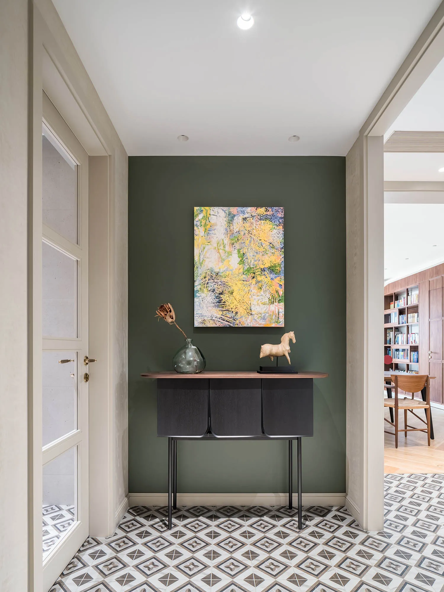 A modern entryway featuring a patterned tile floor and minimalist design elements.