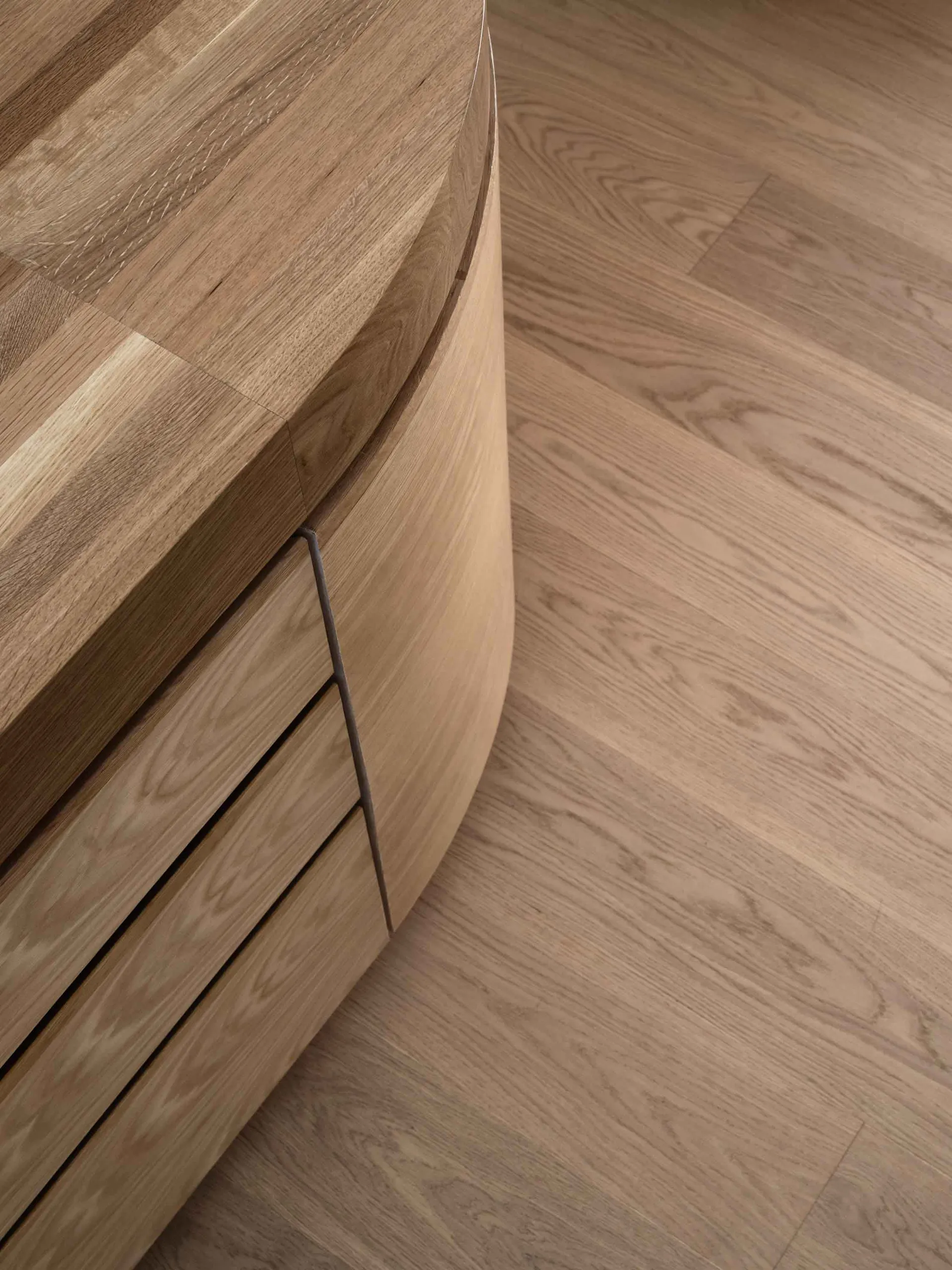 A modern interior design featuring a curved wooden case with a textured surface and minimalistic styling.