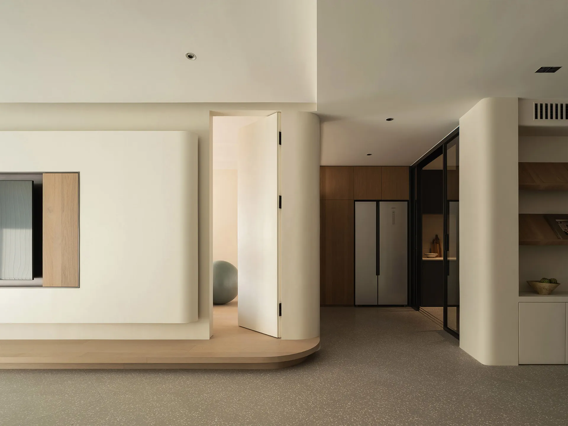 A modern living room with neutral-colored walls and flooring, featuring sleek furniture and minimalist design.