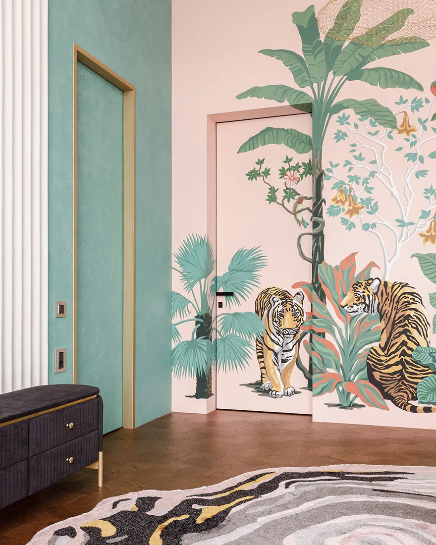 A modern interior with pink walls depicting a tropical jungle theme, including two tigers and lush greenery.