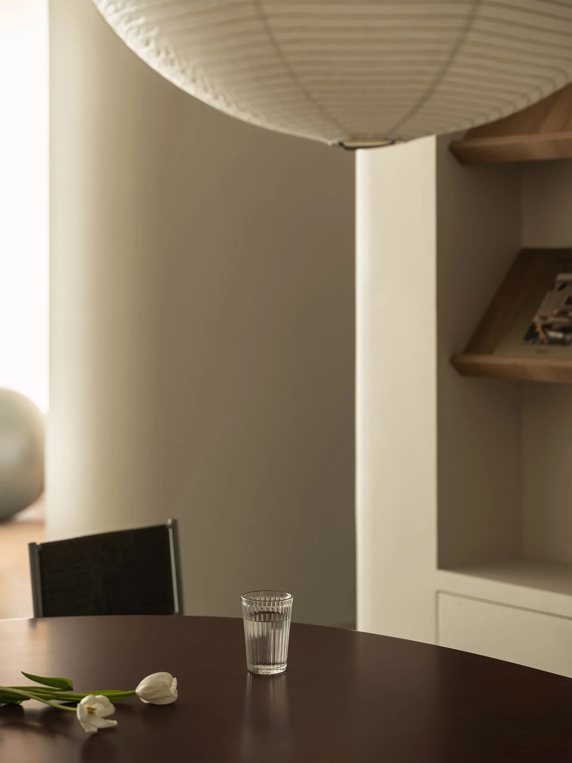 A minimalist interior with wooden furniture and glass elements.