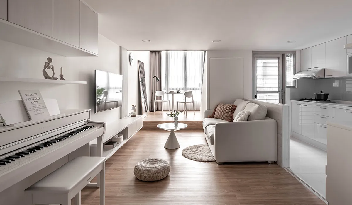 A modern minimalist living room featuring white furniture and wooden accents.