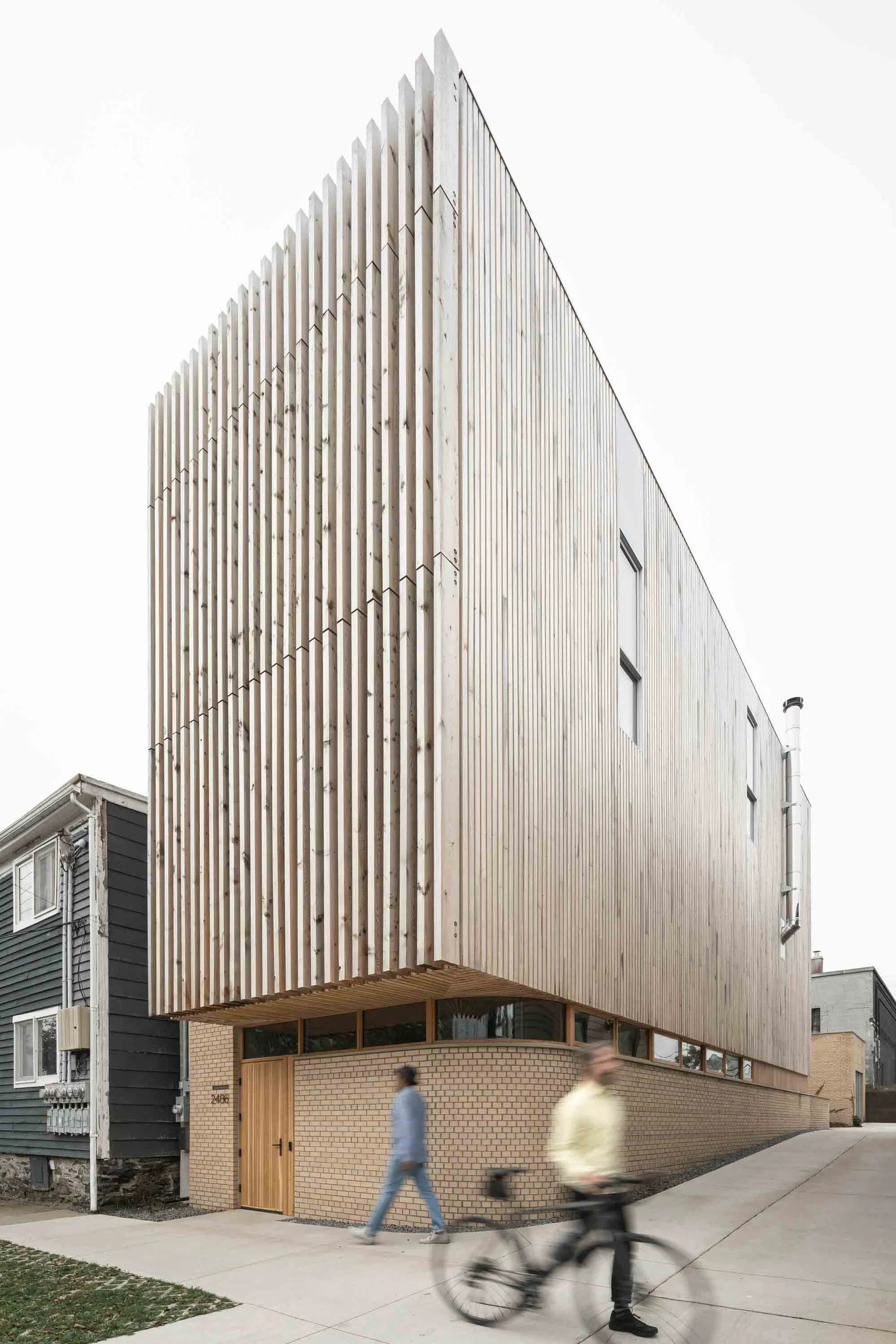 A modern residential building with a wooden facade and slatted wooden panels.