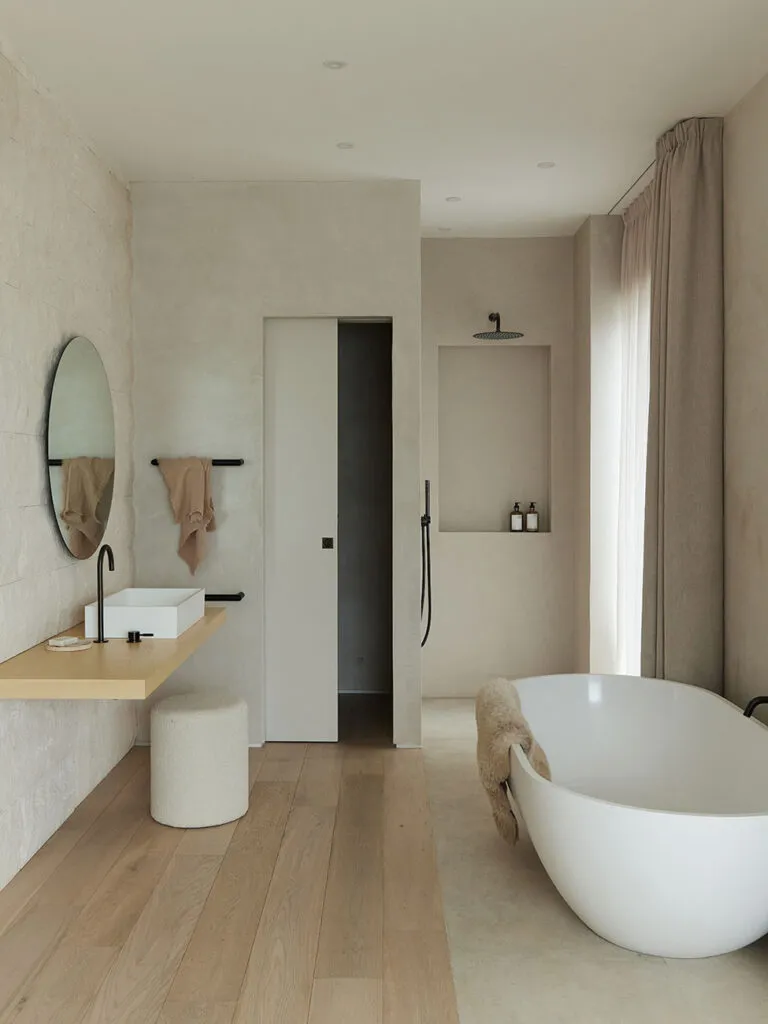 Modern bathroom with concrete walls, a freestanding bathtub, and minimalist design.
