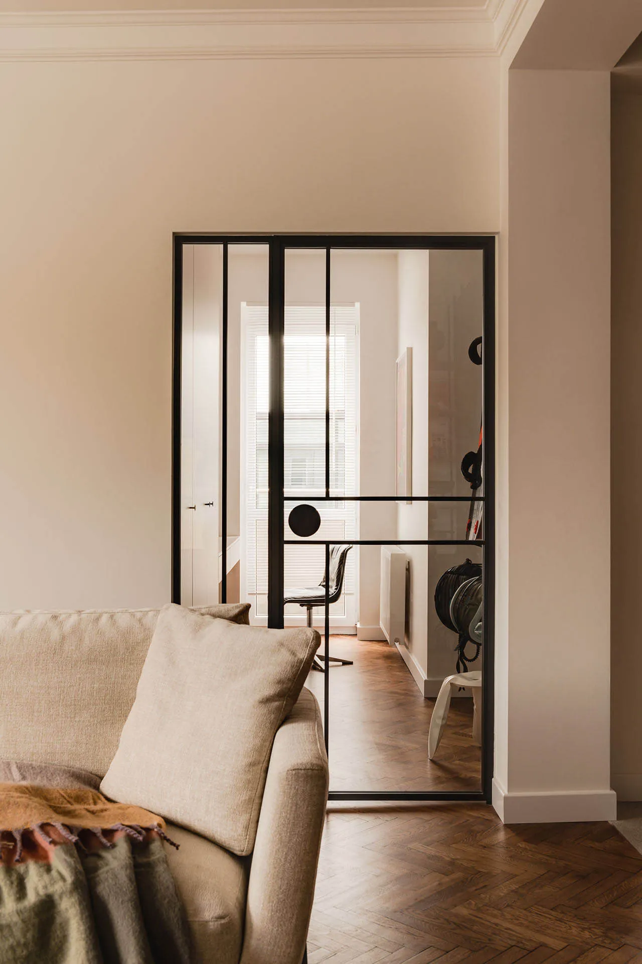 A minimalist living space featuring a glass sliding door and a wooden floor.