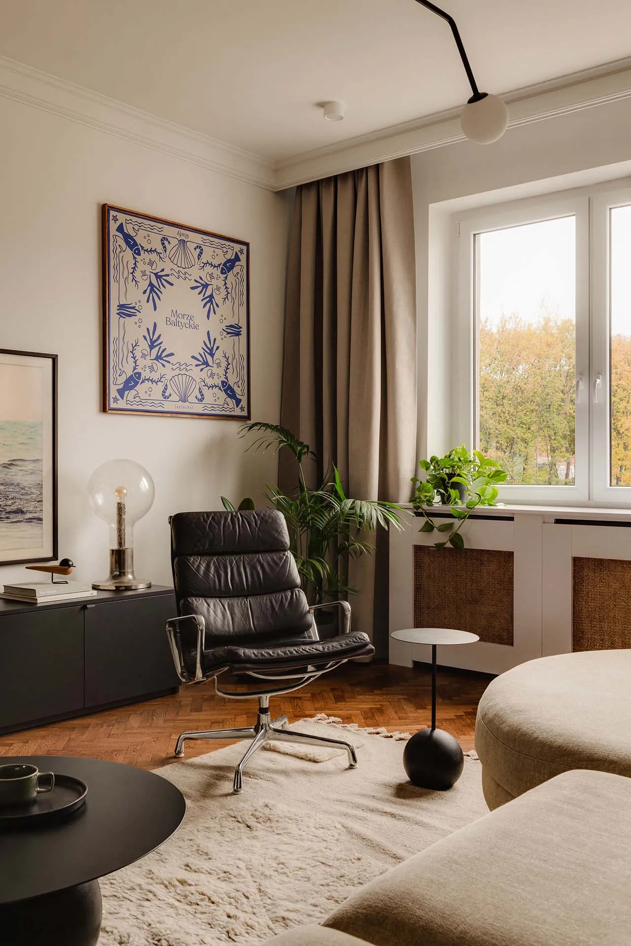 A modern living room with minimalist furniture, neutral color palette, and a mix of materials including wood, leather, and fa