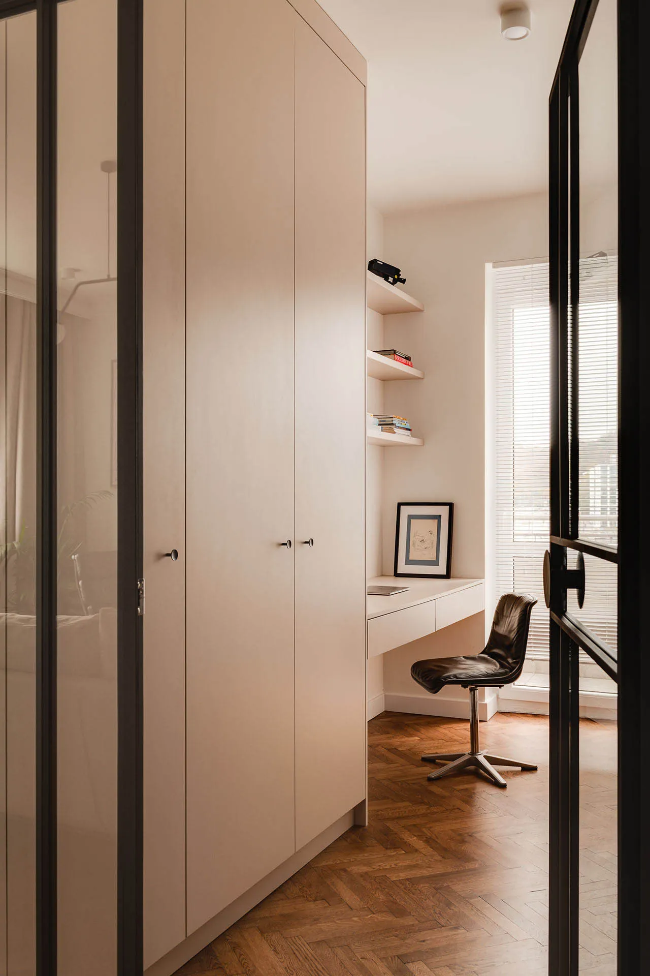 Contemporary minimalist home office featuring a sleek white desk and modern white cabinets.