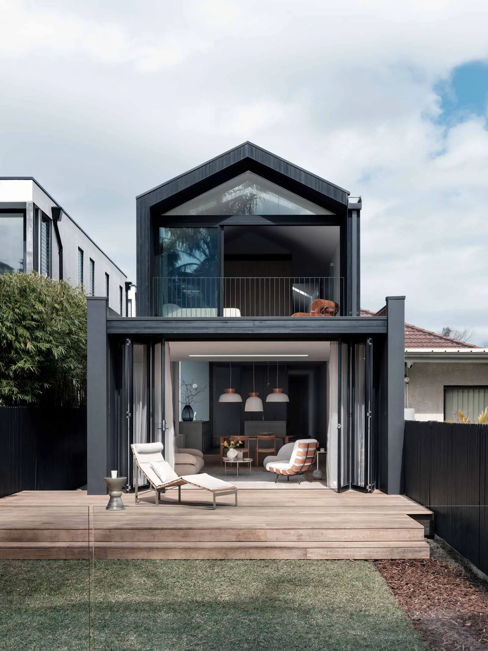 Modern residential exterior featuring a combination of glass and wood materials with a contemporary design.