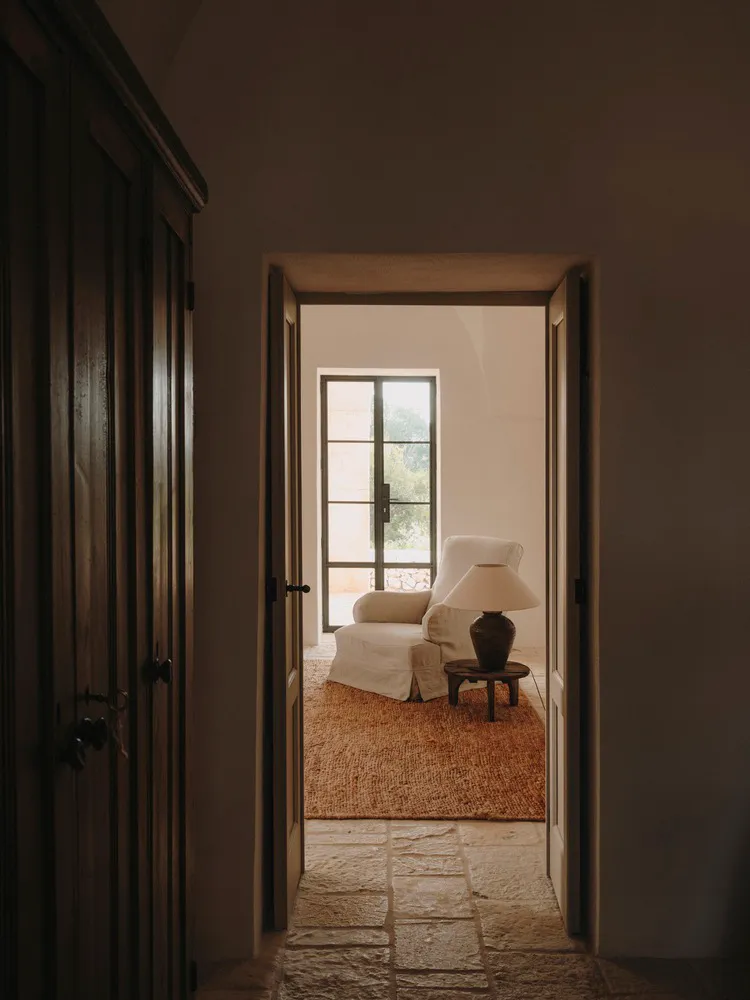 Interior of a minimalist room with a cabinet, glass window, and wooden floors.