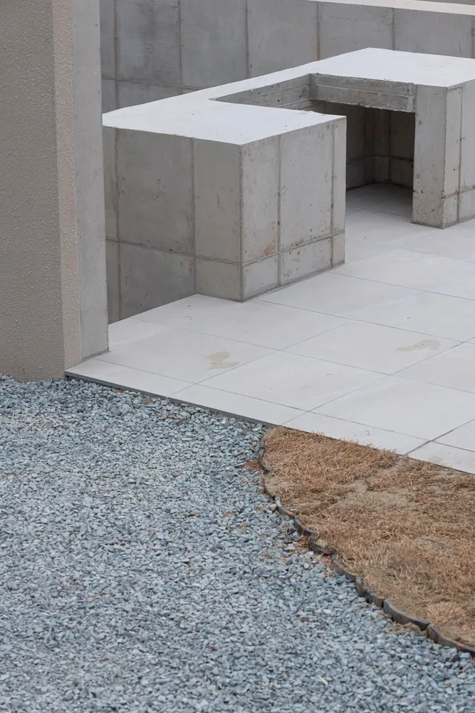 A concrete structure with a gravel area and sparse grass.