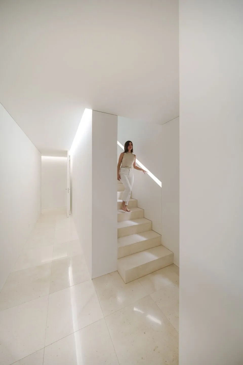 A minimalist interior with a white marble staircase.