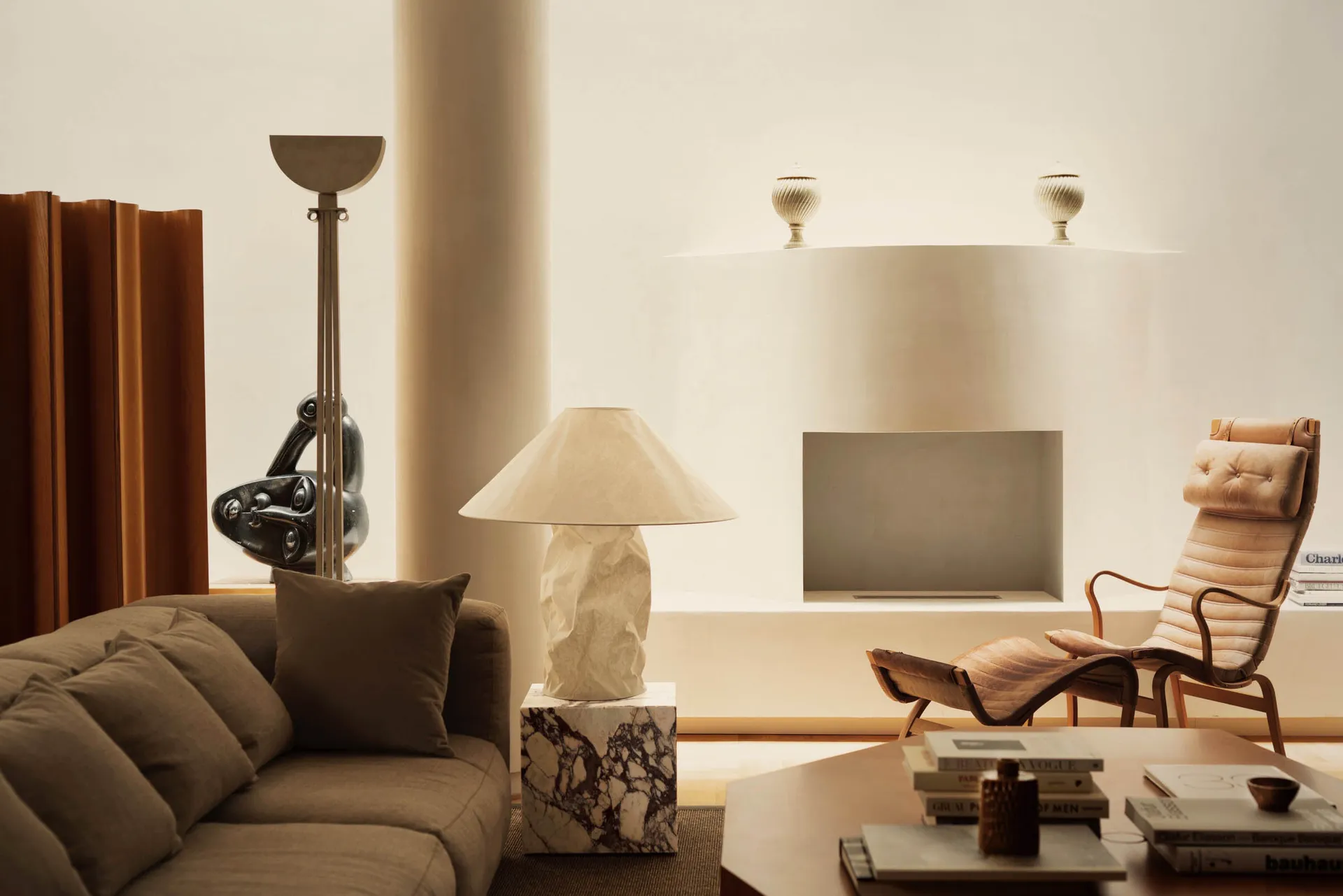 A minimalist living room featuring marble and leather elements.