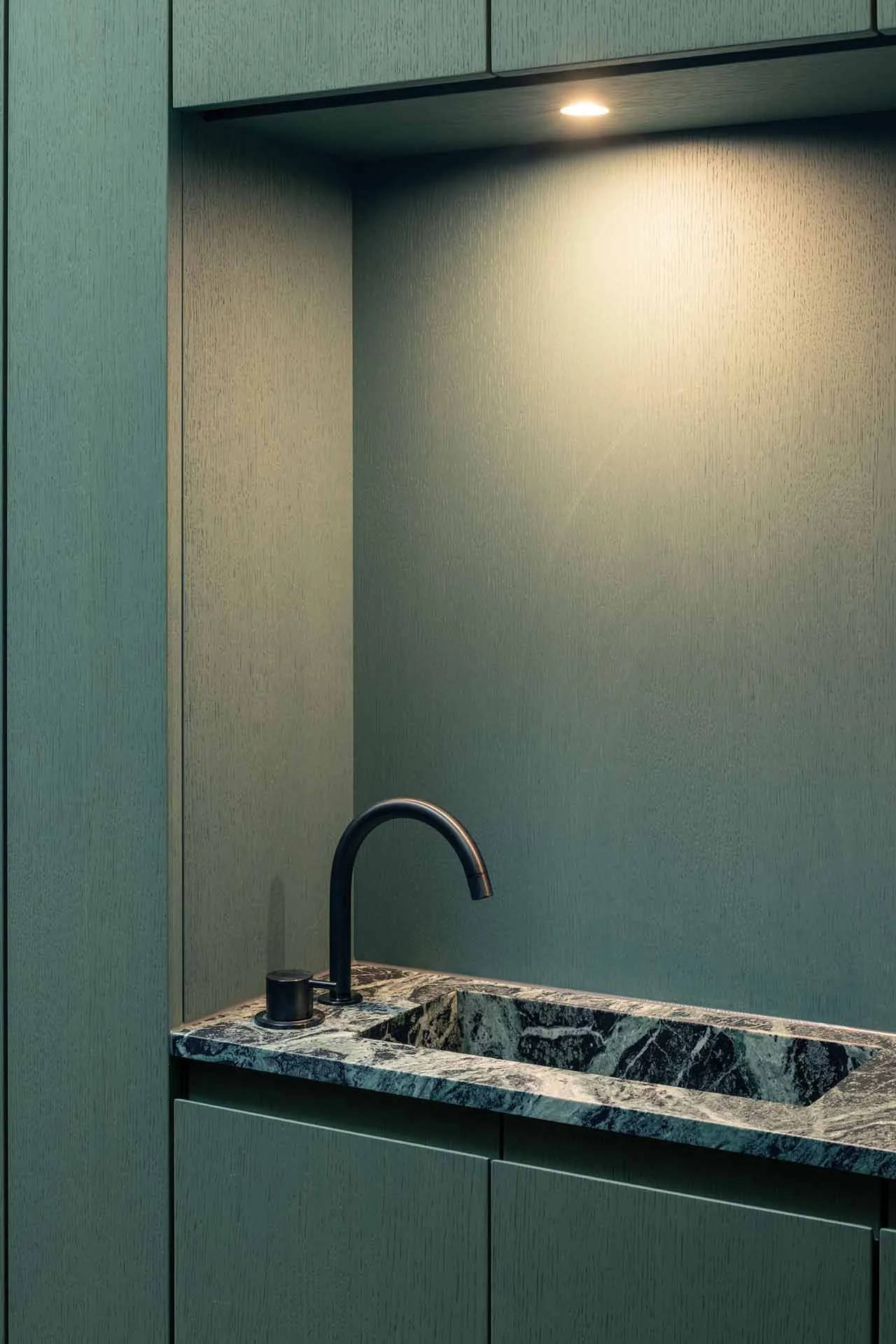A modern kitchen with a marble countertop and cabinet fronts.