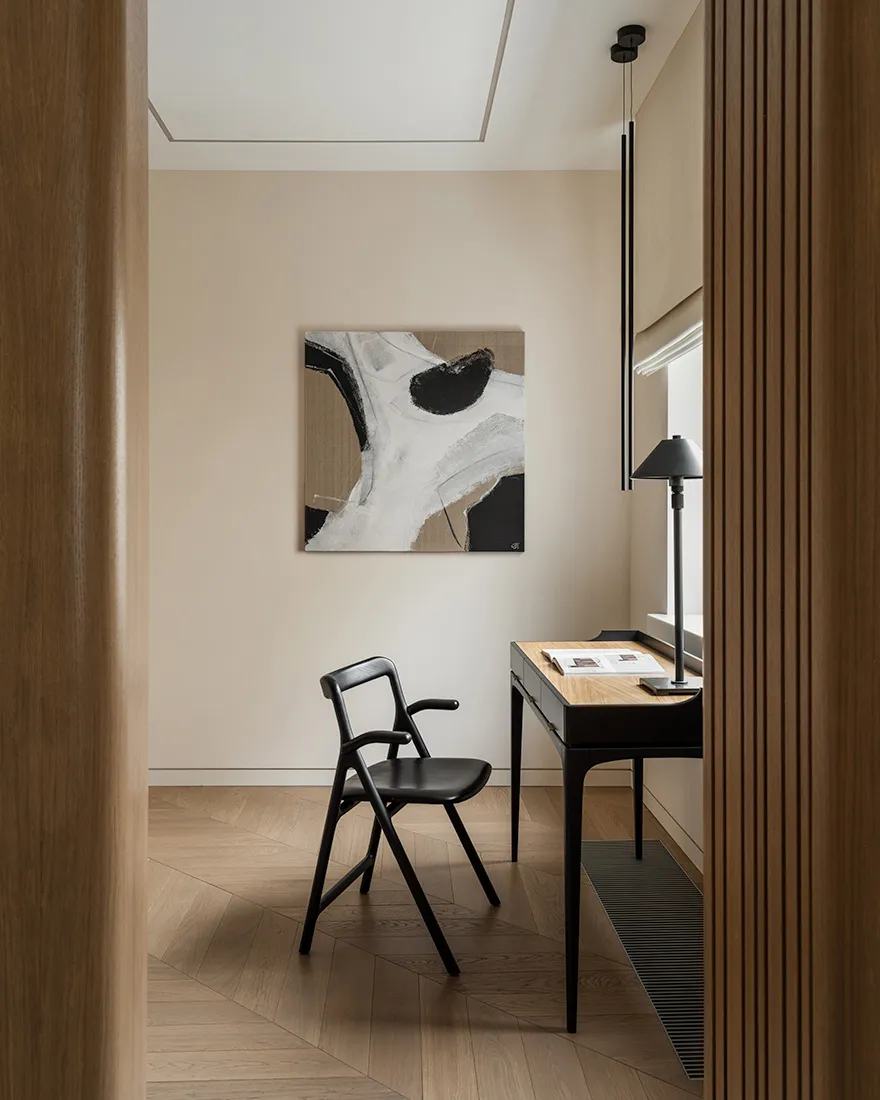 A modern home office featuring a black chair and desk with wooden furnishings.