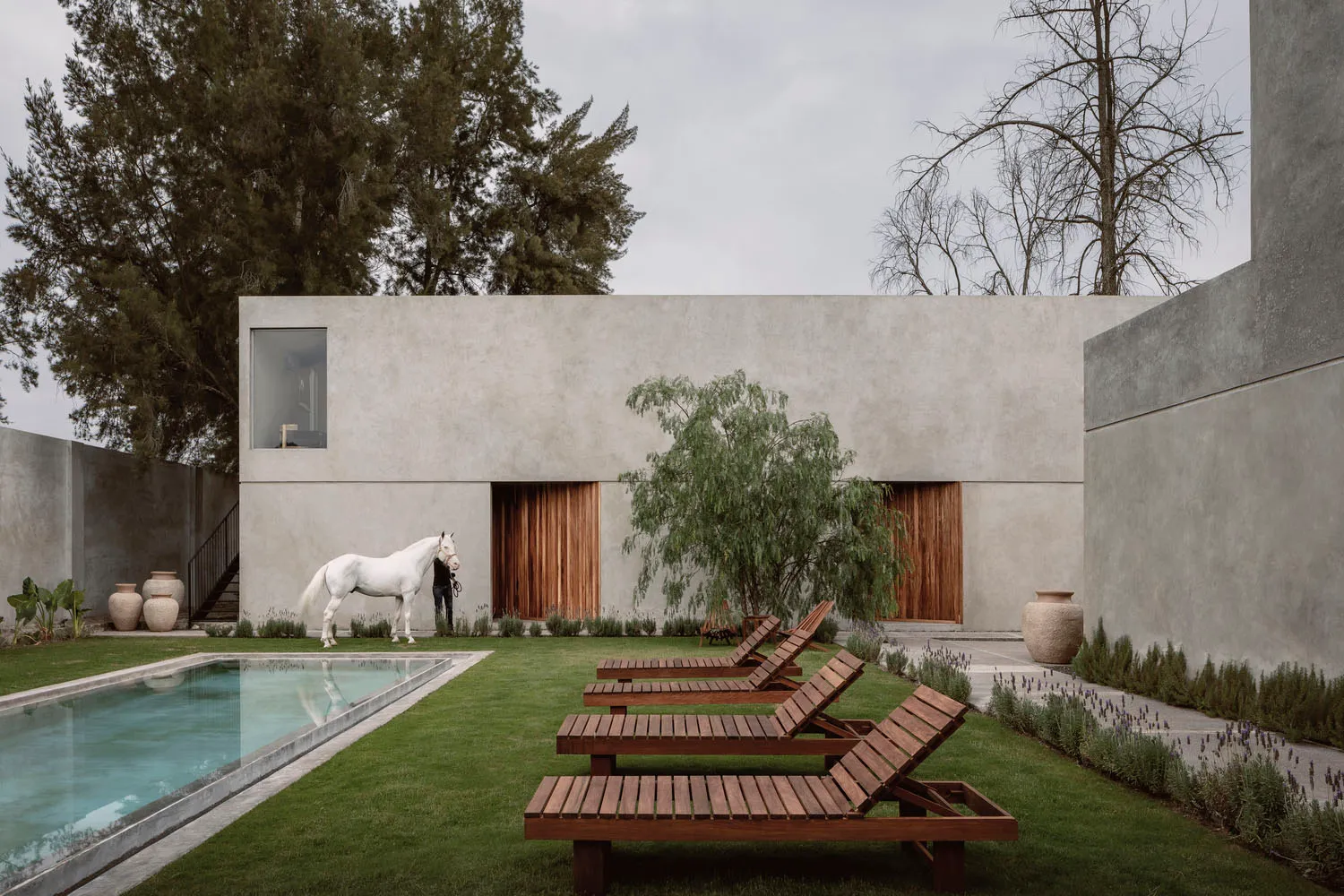 A minimalist residential exterior made of concrete and wood materials.