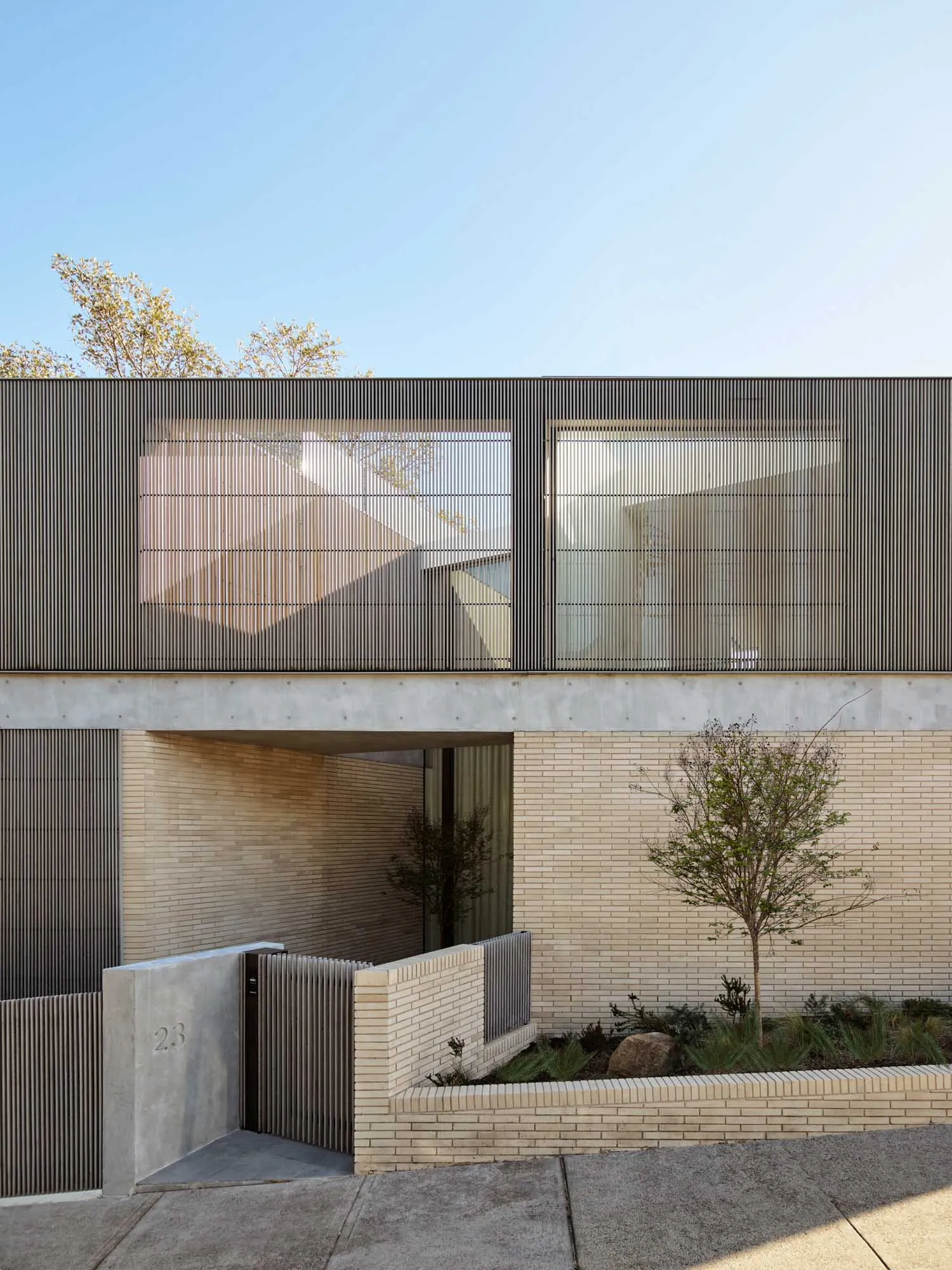 Modern residential house made of brick, concrete, and metal materials.