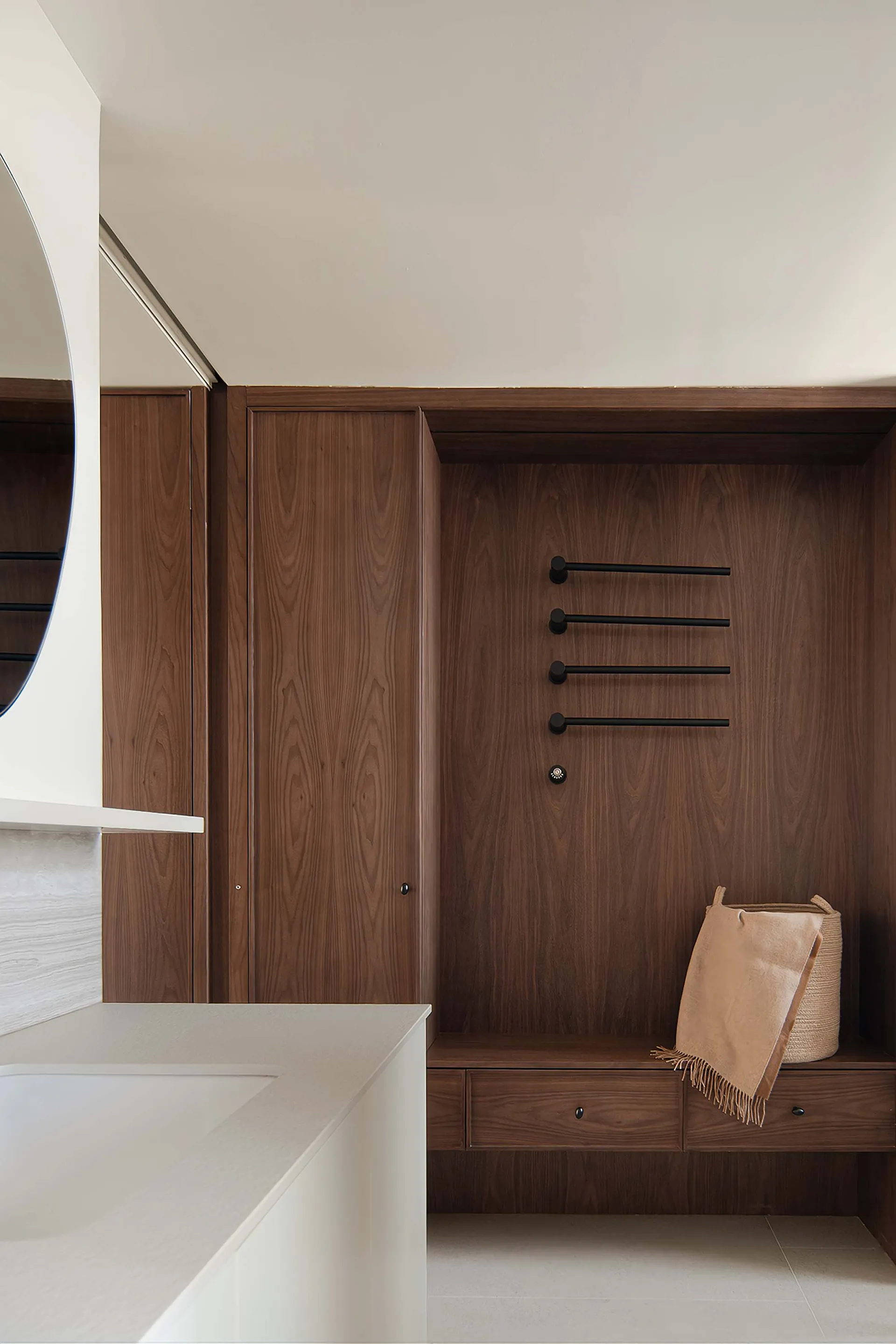 Modern wooden closet storage with towel racks and drawers.