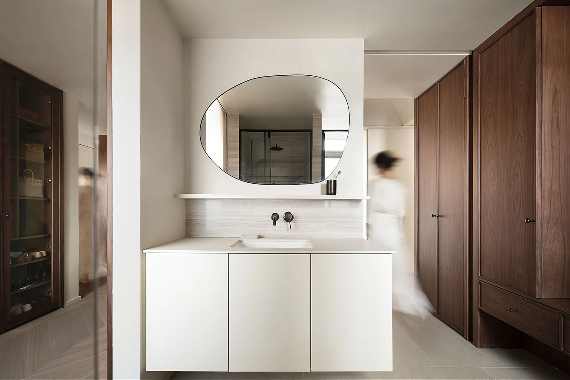 Modern minimalist bathroom with white cabinets, marble countertop, and wooden cabinets.