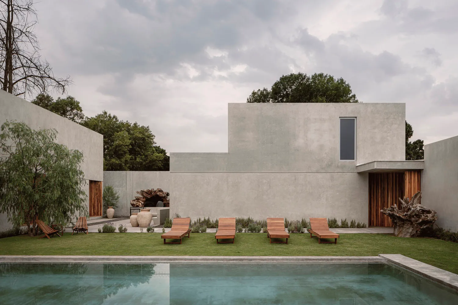 A modern, minimalist exterior with a concrete exterior and a swimming pool.