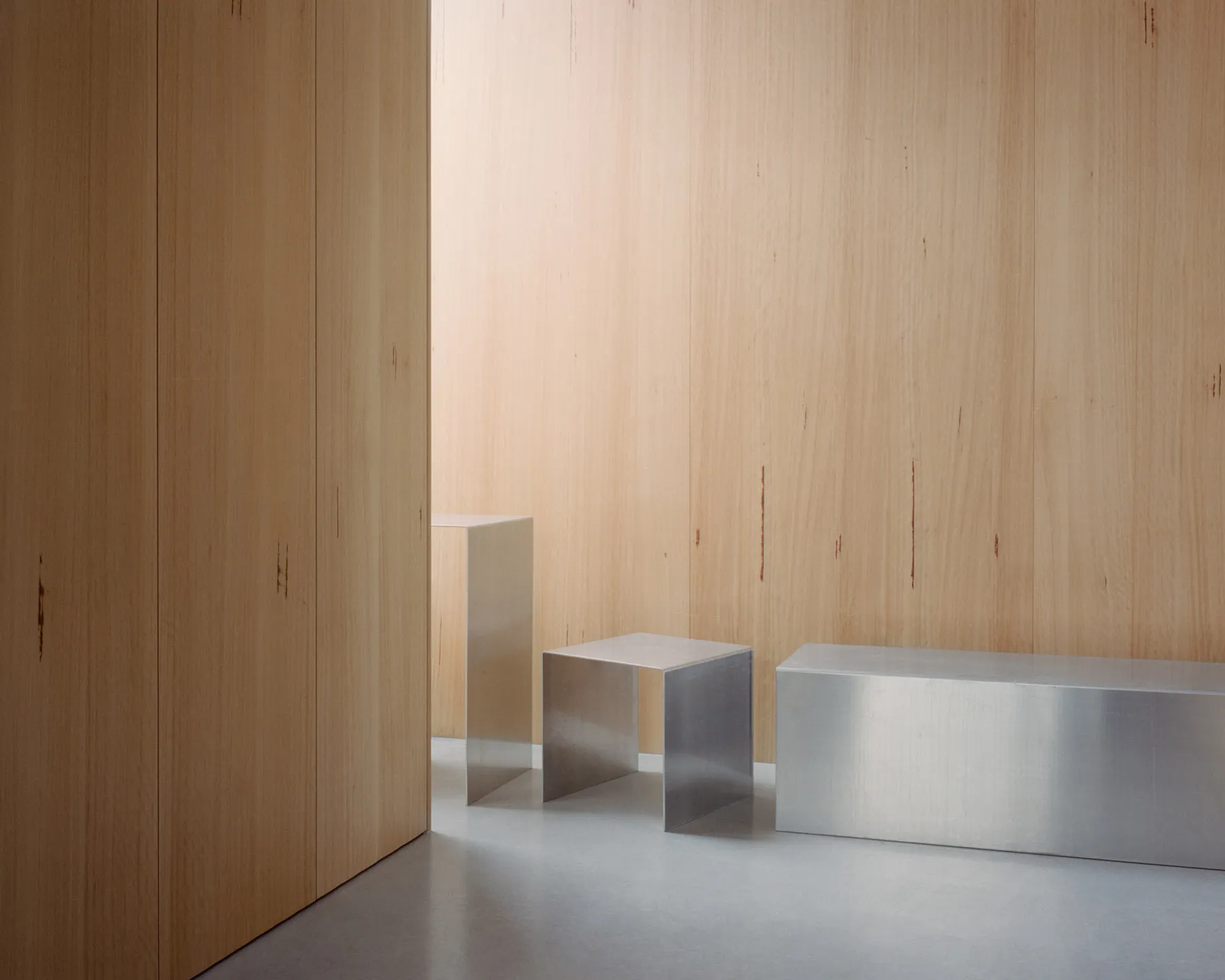 Minimalist design featuring metallic stools in an interior space.
