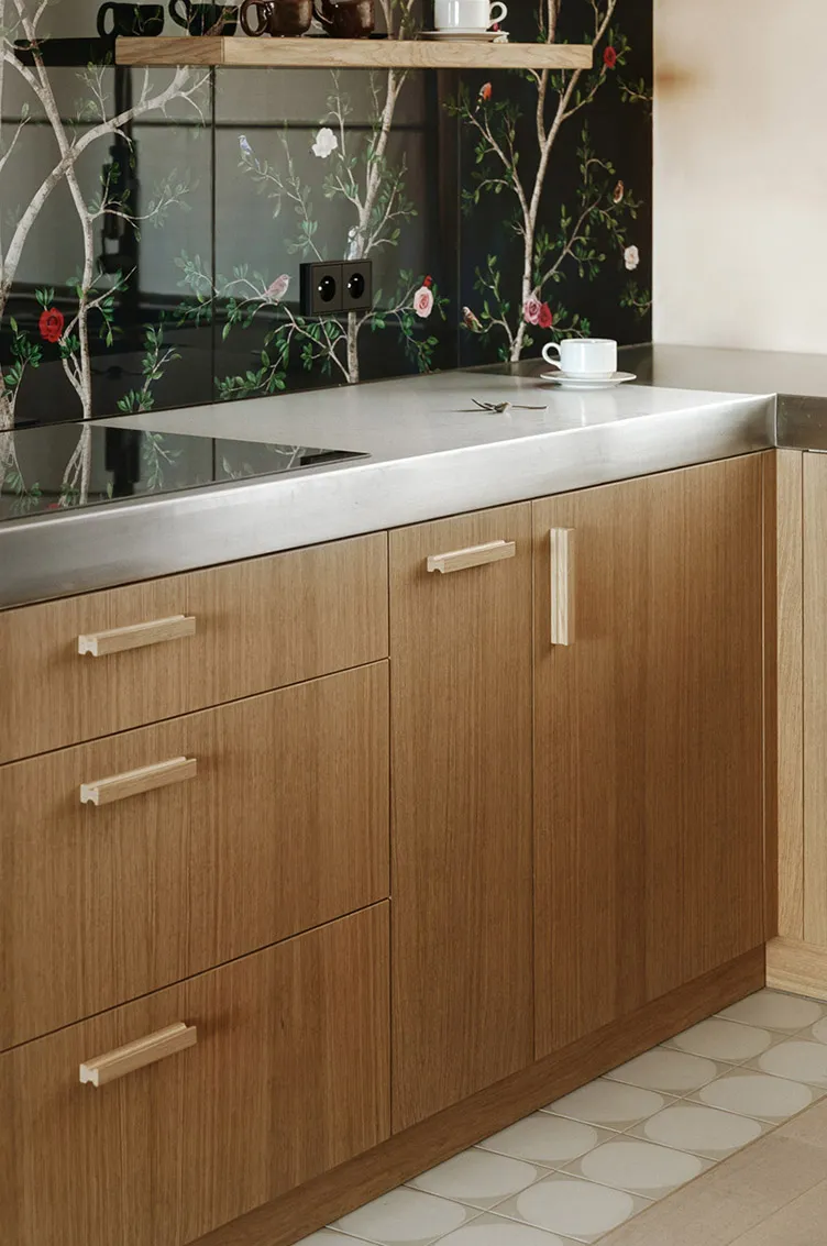 Modern, minimalist kitchen with wooden cabinets and stainless steel countertops.