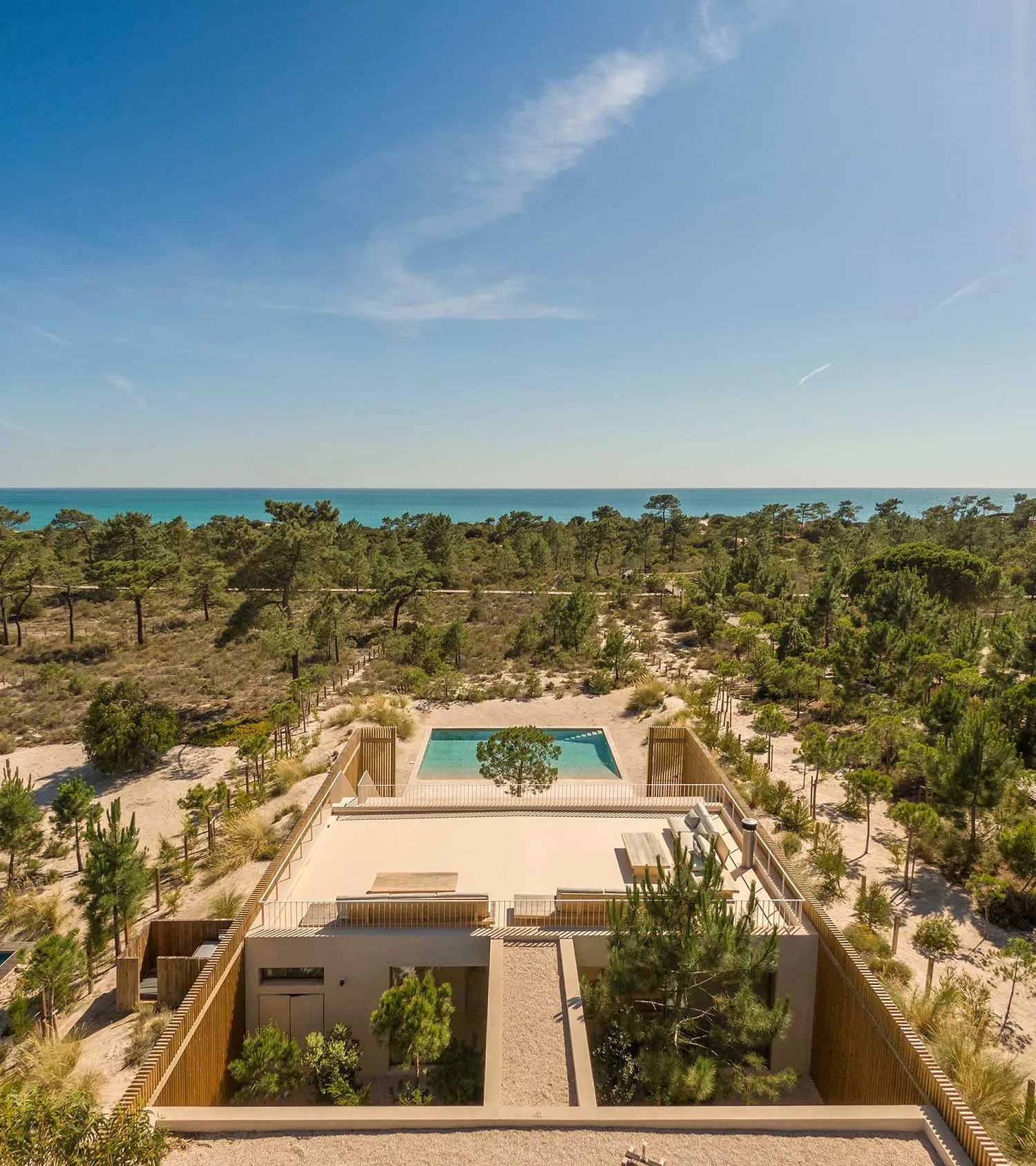 A modern vacation home with a pool surrounded by nature.