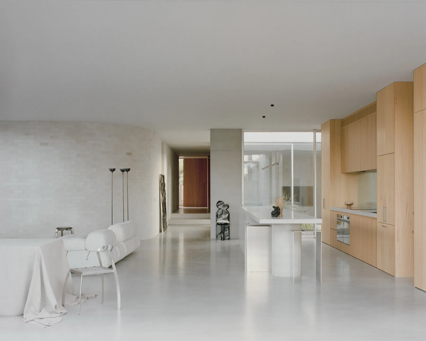 Minimalist residential kitchen with concrete flooring, minimalist furniture, and sleek, modern design.