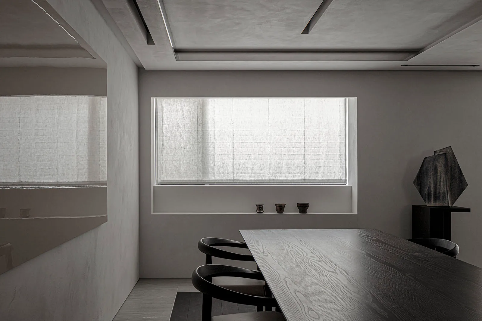 A minimalist interior design with a wooden dining table and chairs, featuring a large window with sheer curtains and a wall-m