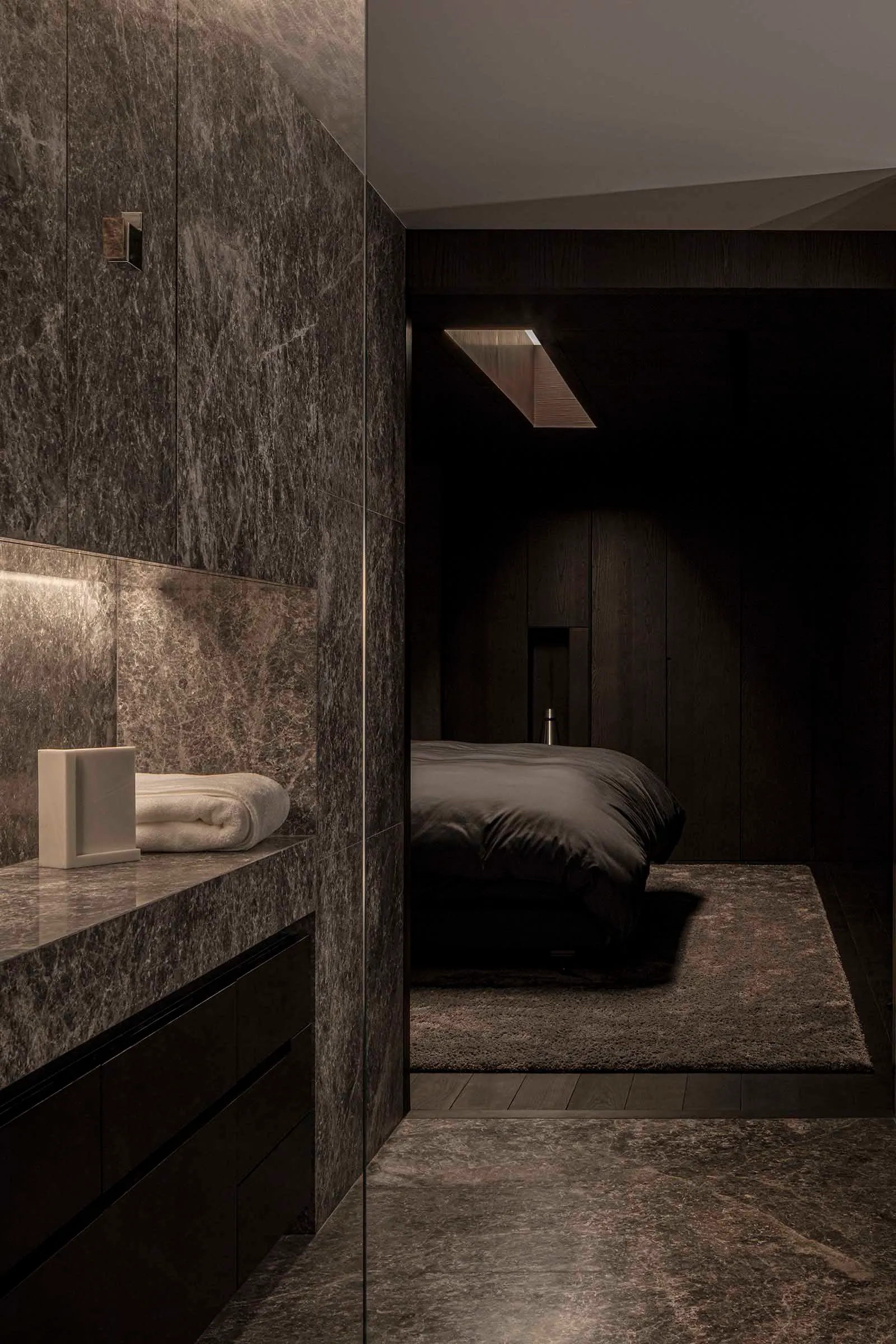 A modern bedroom featuring a marble wall and floor.