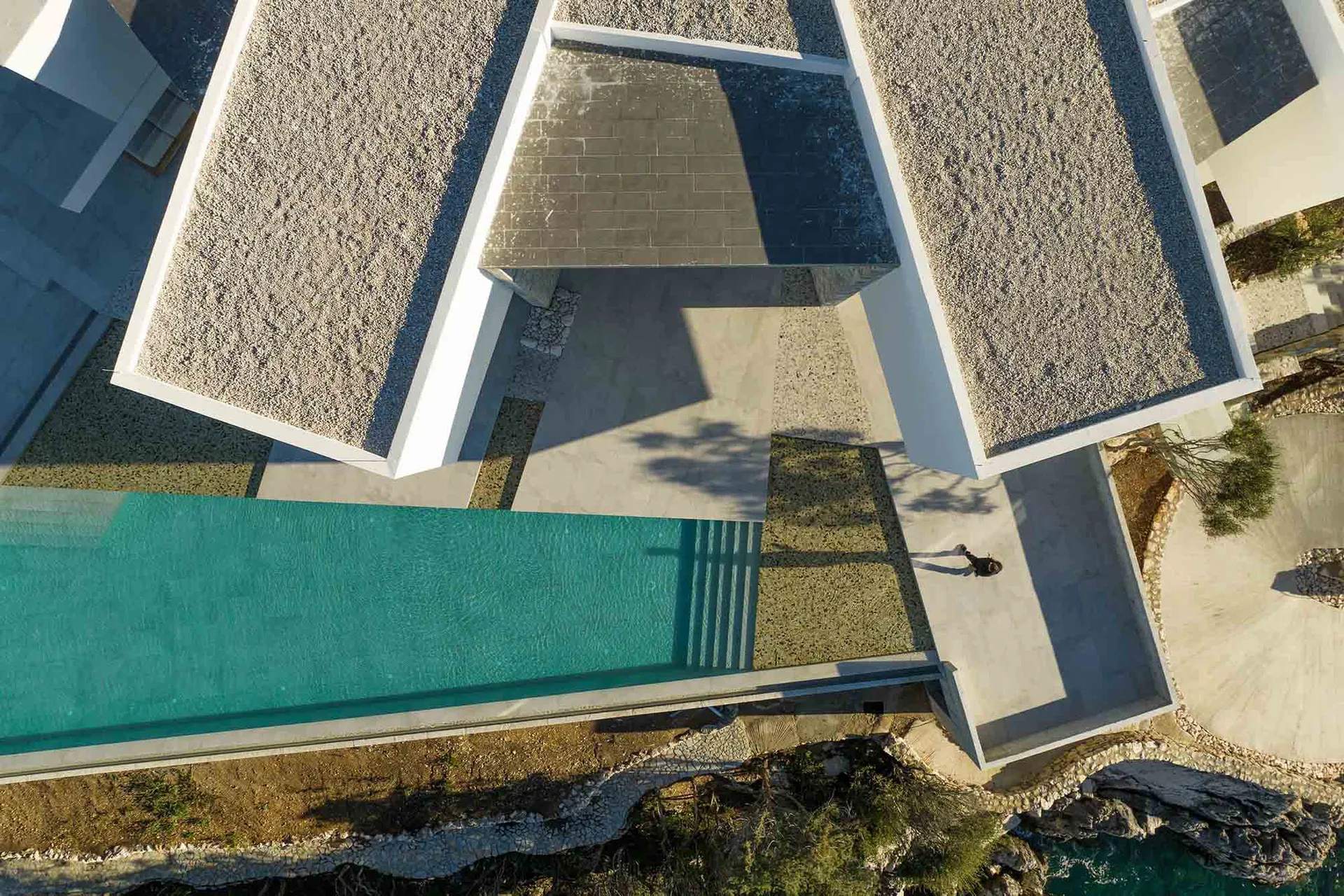 Aerial view of a modern residential exterior with concrete structures and a pool.