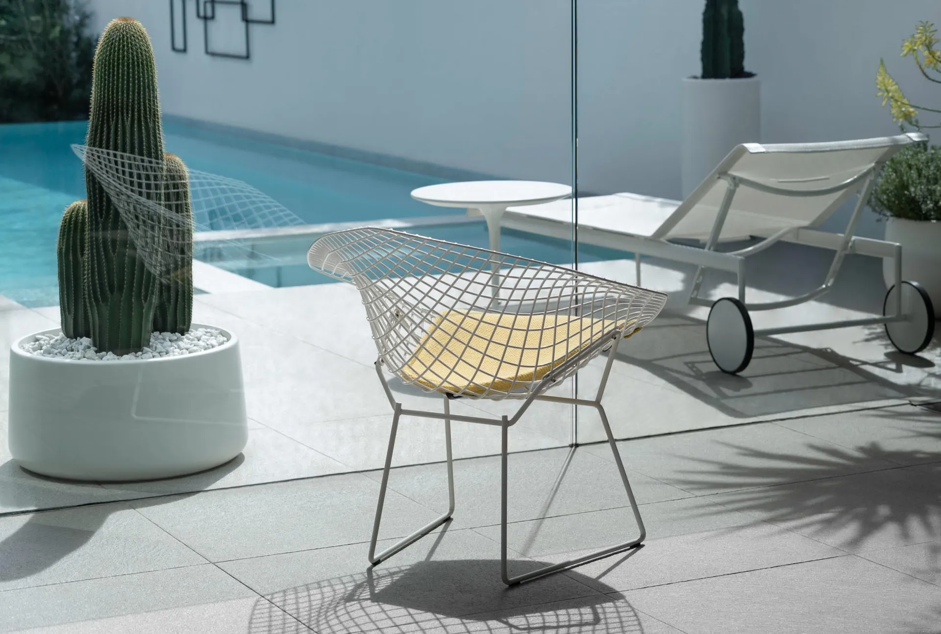 A modern metal chair with a yellow cushion placed on a terrace.