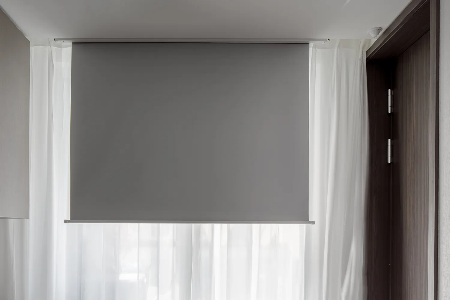 Modern window blinds and sheer white curtains in a contemporary interior design setting