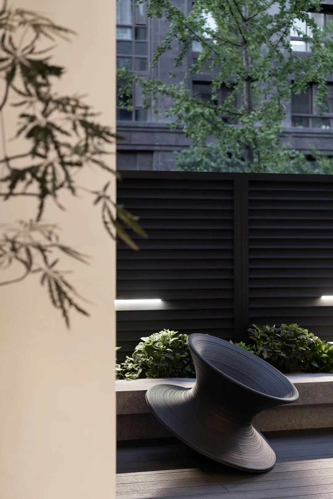 A minimalist black metal outdoor seating area with a unique, curving design.