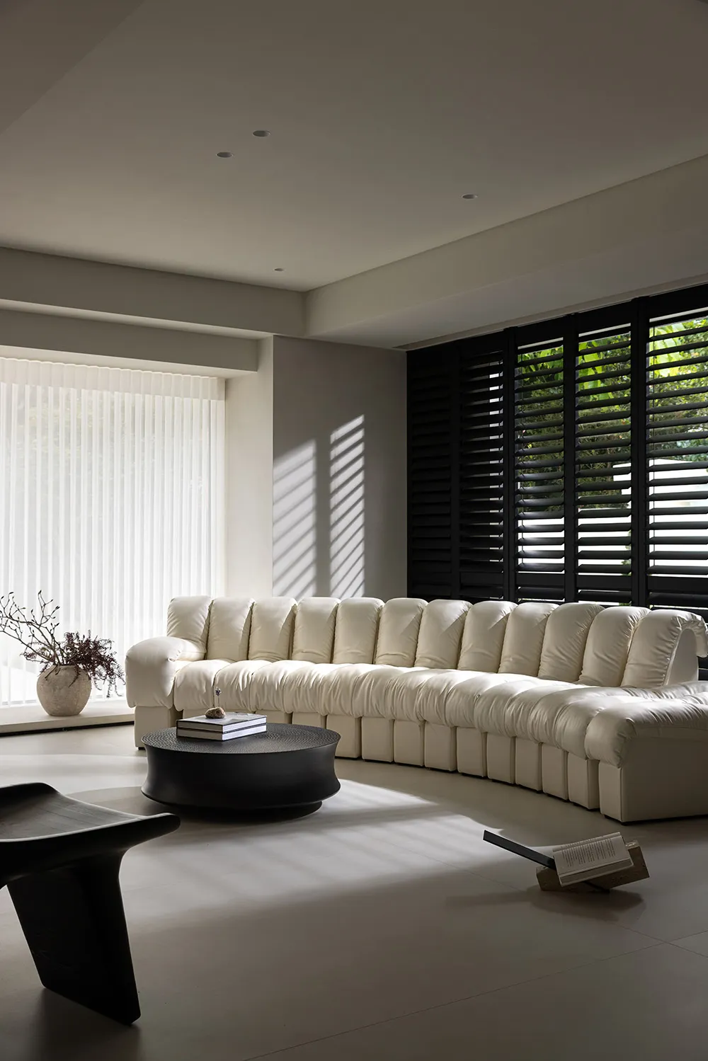 Modern white fabric sofa in a living room with sunlight streaming through the window.