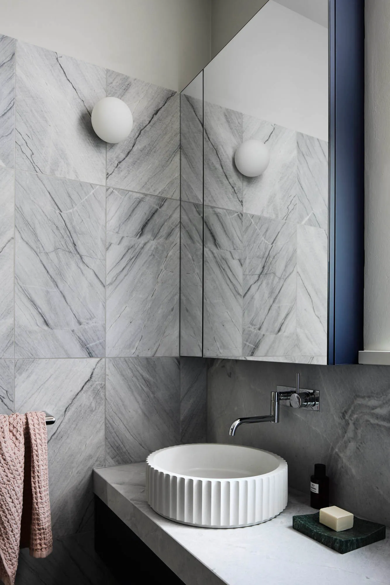 A modern minimalist bathroom with marble walls.