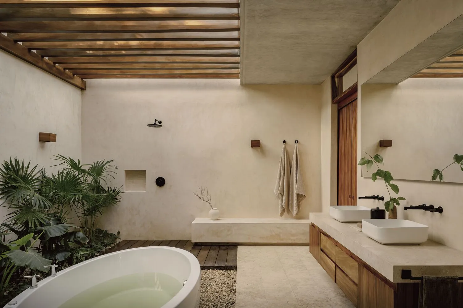 A modern bathroom with concrete walls, a freestanding bathtub, and natural light.