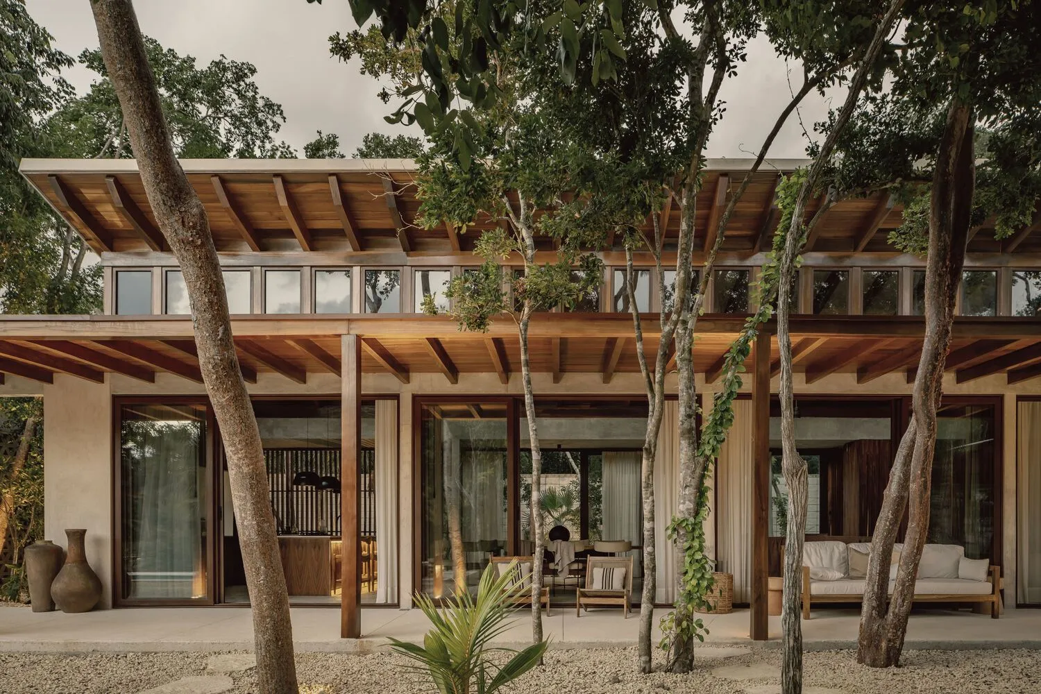 Modern residential exterior with wooden accents, concrete walls, and glass doors.