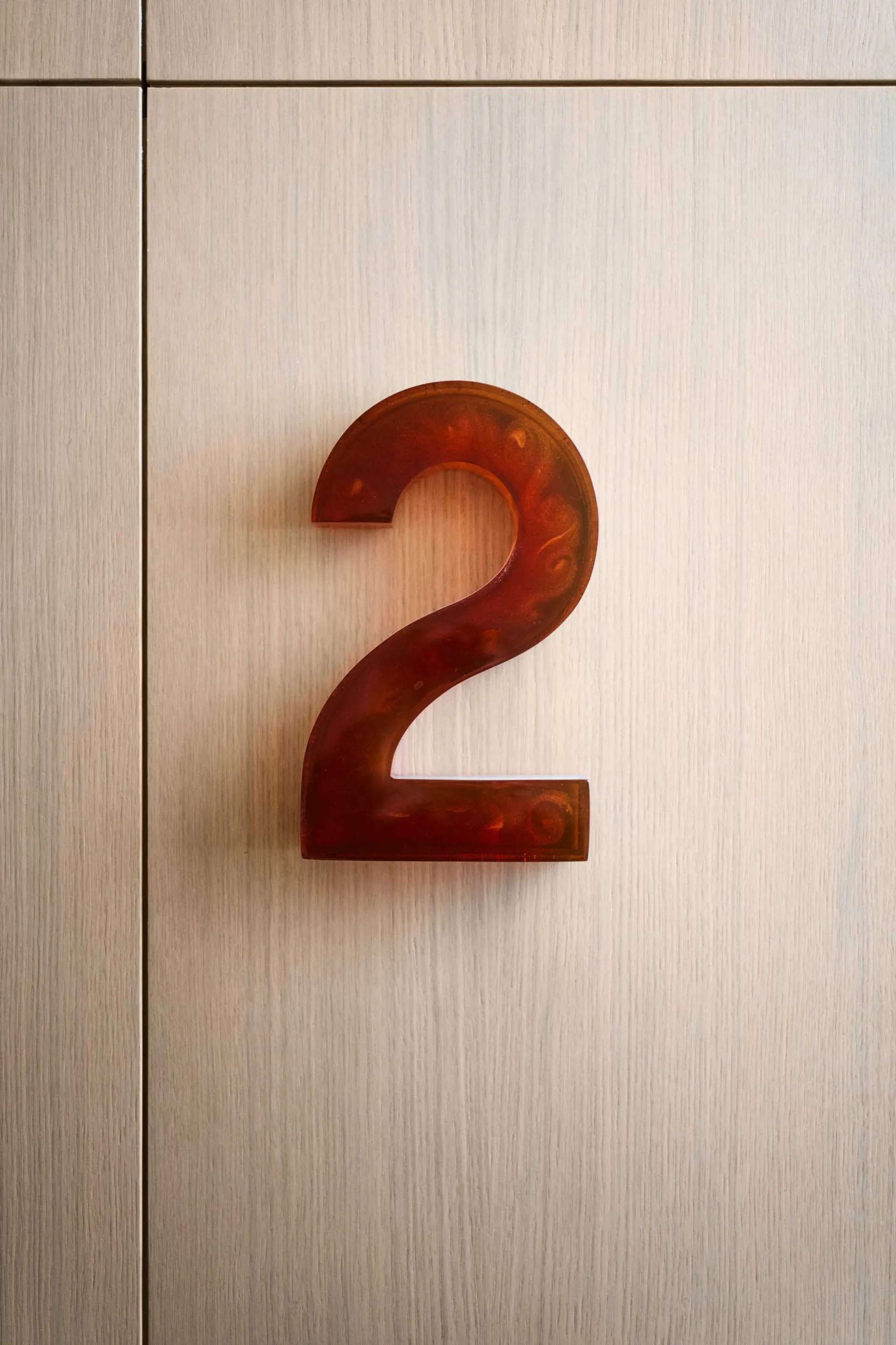Modern minimalist building number sign on a wooden wall