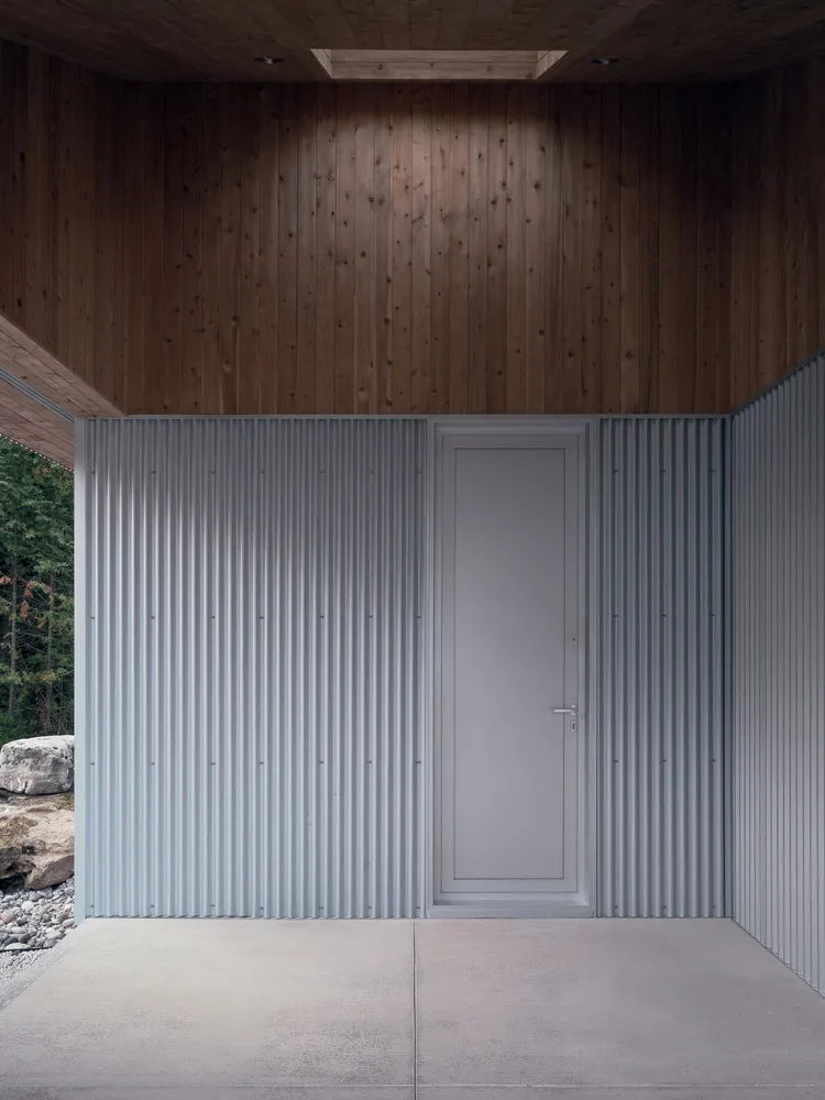 Modern minimalist entrance with corrugated metal materials and concrete floor.