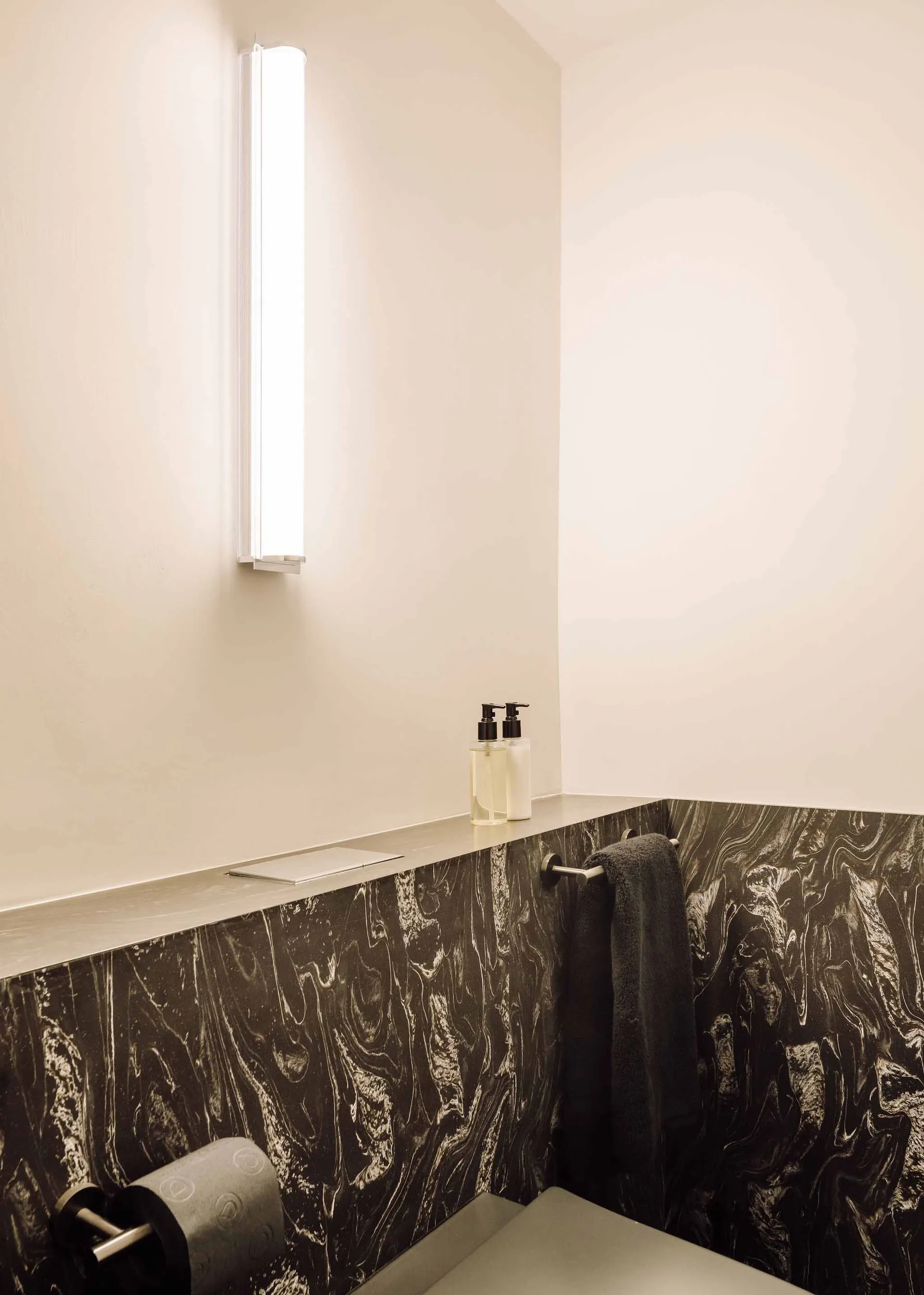 Modern minimalist bathroom featuring a slide with marble and concrete materials.