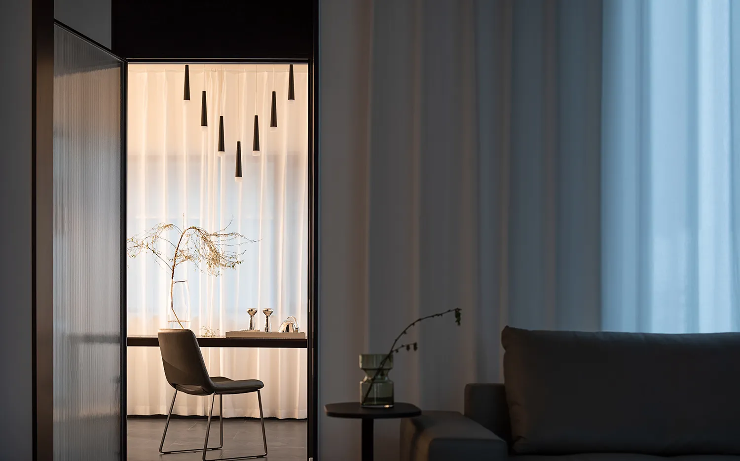 A minimalist living room features neutral-toned textiles, modern furniture, and a calm, curated atmosphere.