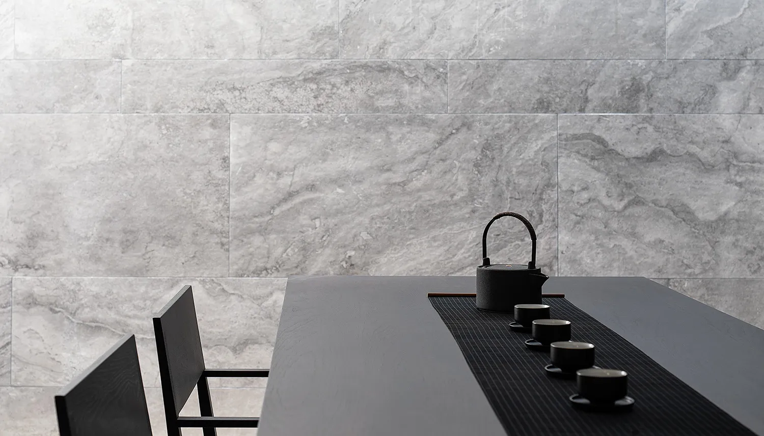 Modern, minimalist tea ceremony setting with concrete walls and a black table.
