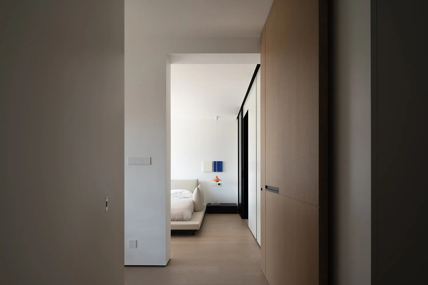A modern minimalist bedroom featuring neutral tones and a sleek design.