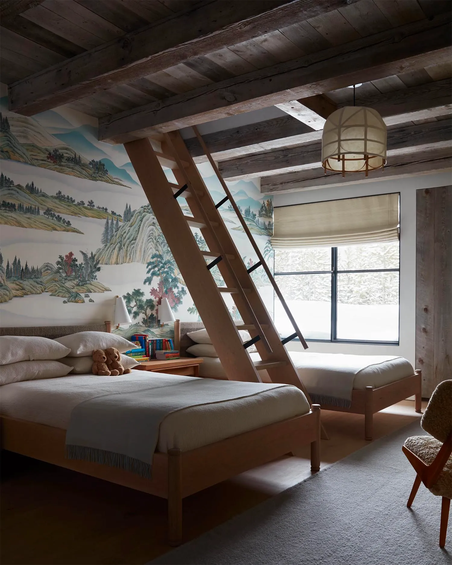 A rustic, industrial-style bedroom featuring wooden furniture and a mural of mountain landscapes on the wall.