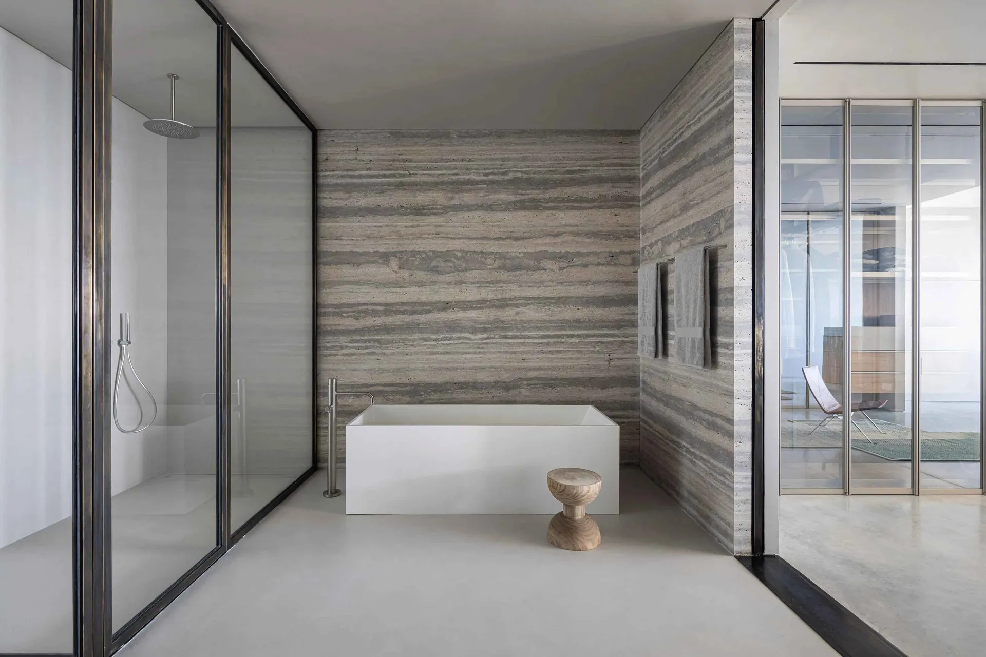 現代浴室設有獨立浴缸、混凝土牆面與洞石地板。