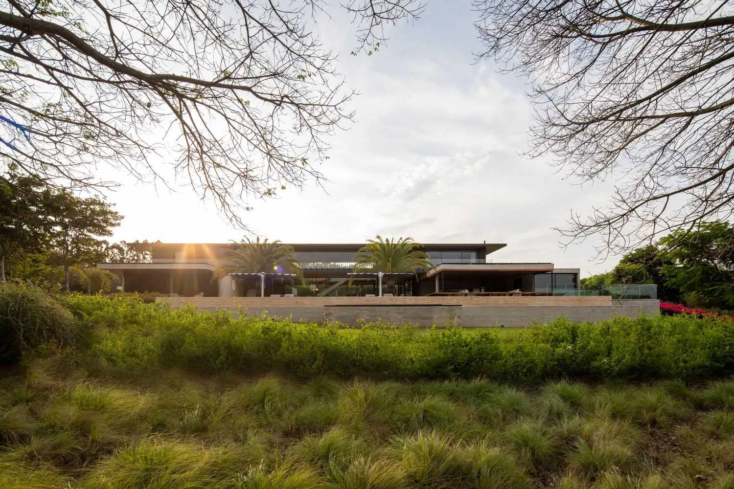A modern residential exterior with glass, timber, and concrete elements