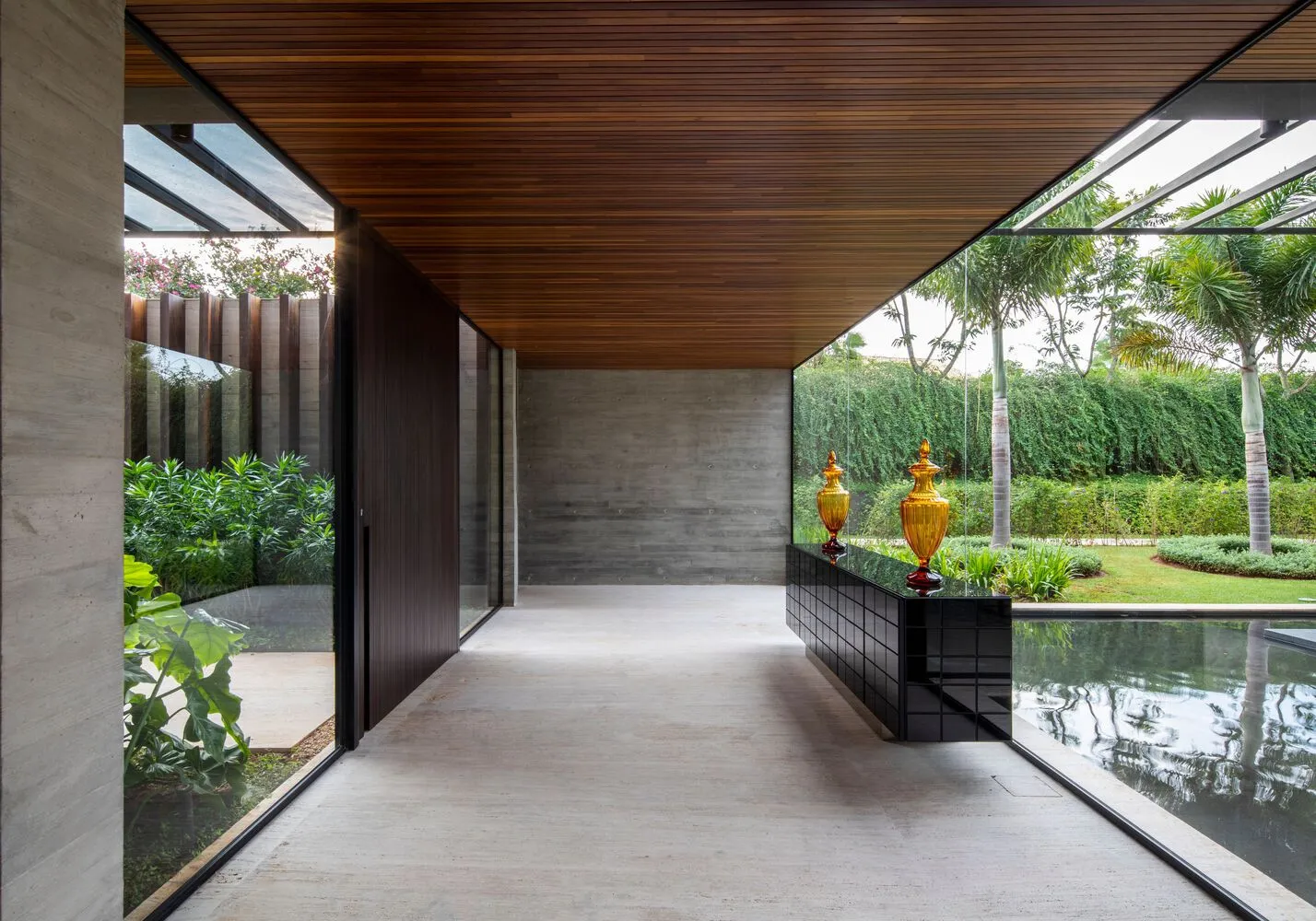 Modern entrance featuring concrete floor and wooden ceiling with large glass windows.