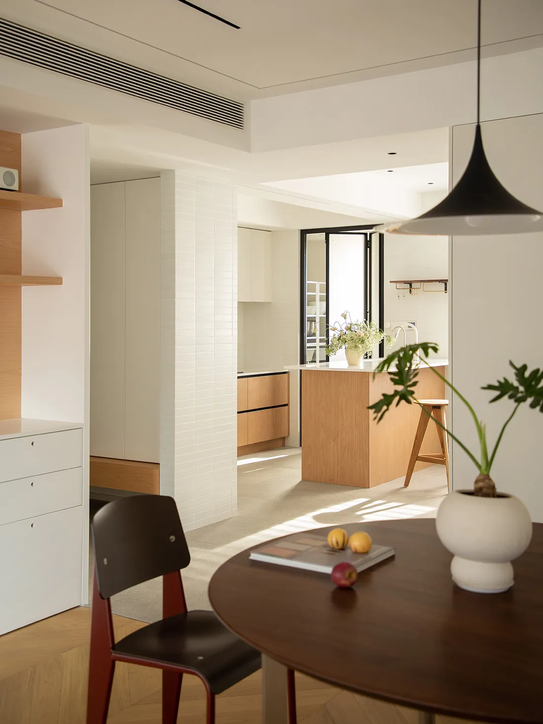 Modern minimalist residential kitchen featuring white cabinets and a wooden island.